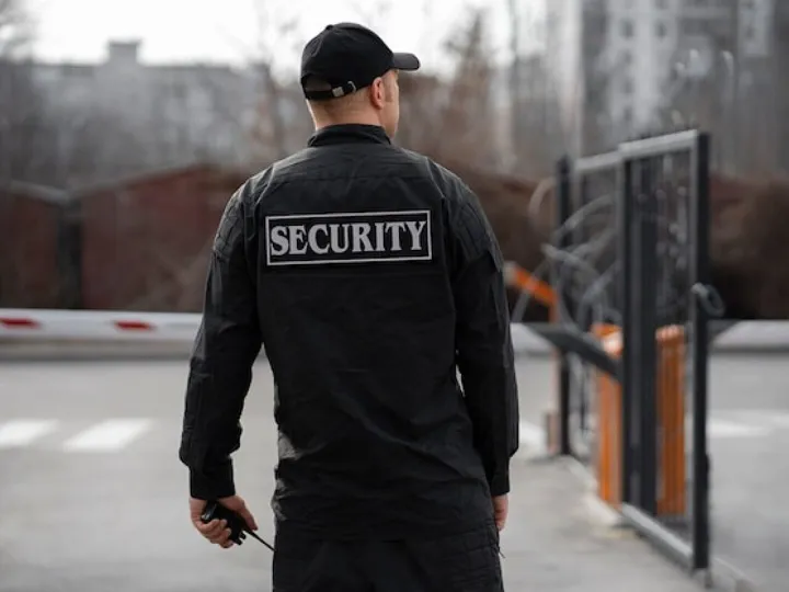 Portrait of male security guard with barbed wire