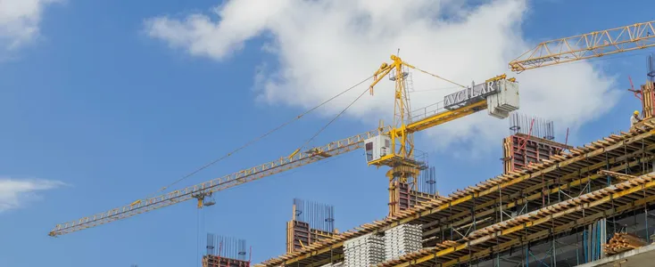 A modern construction site with cranes against a