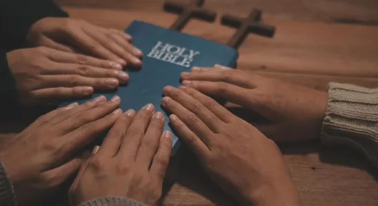 Christian group are praying to god with the bible and sharin