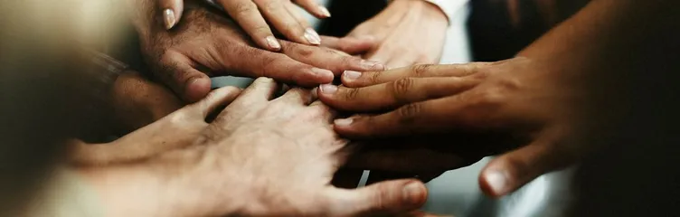 Closeup of diverse people joining their hands