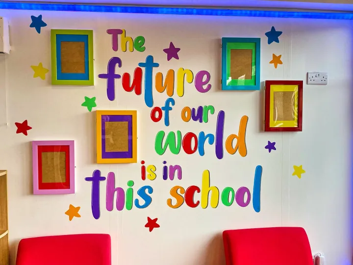Bright classroom wall mural reading The future of our world is in this school
