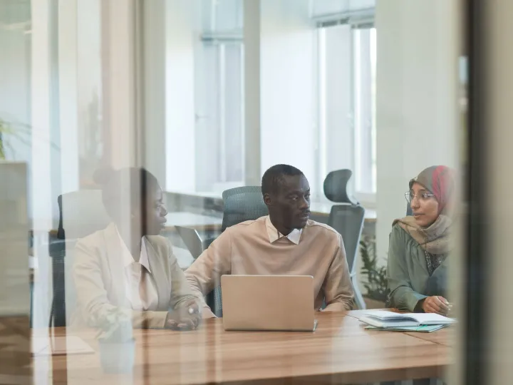 Property professionals in a consultation meeting in a glass-walled office