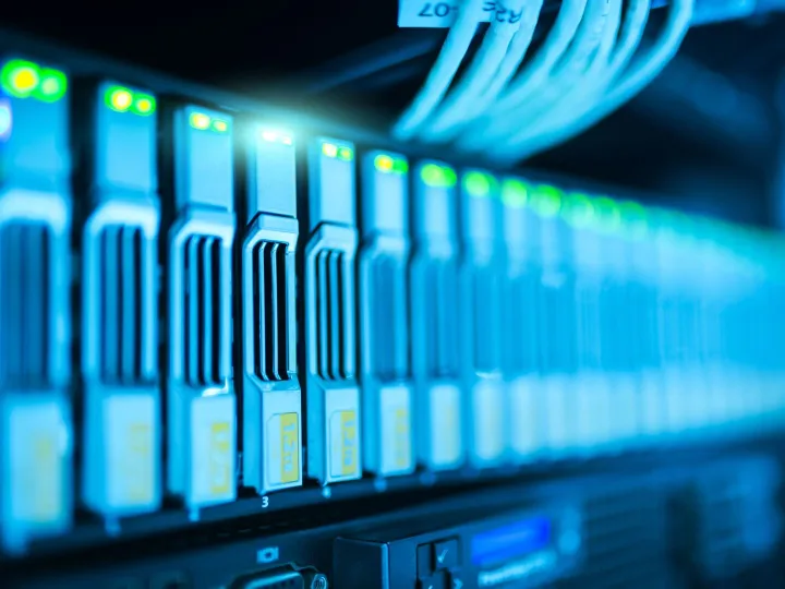 Close-up of a server rack with glowing blue indicator lights