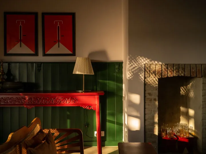 The fireplace and antique red console in the lounge at Peacock Hill Sigiriya