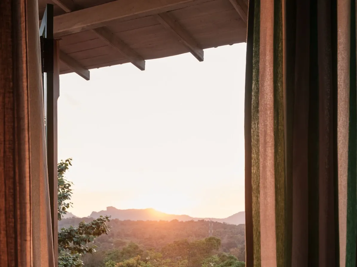 A guest reading on a private balcony as the sun sets at Peacock Hill Sigiriya