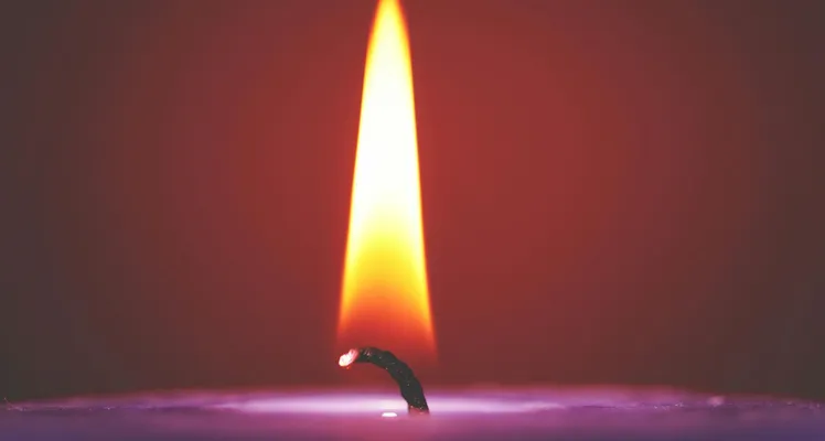 Close-up of a glowing candle flame against a dark