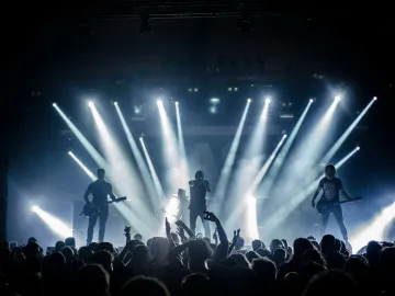 Energetic live concert with musicians performing on stage, engaging the crowd with vibrant lighting effects.