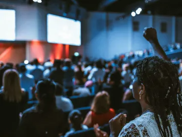 Vibrant crowd at a conference with a focus on an attentive participant.