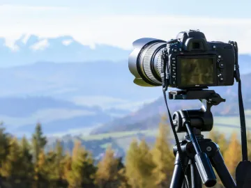 DSLR camera on tripod capturing a stunning mountai
