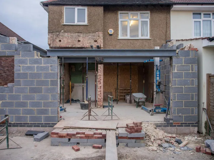 Brick house under renovation with an extension in
