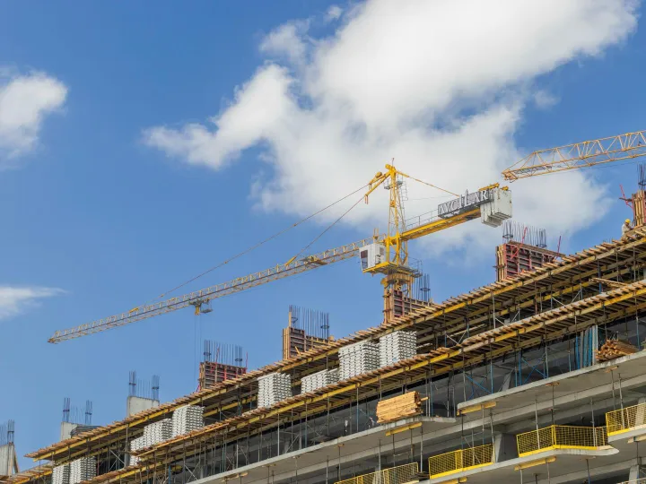 A modern construction site with cranes against a