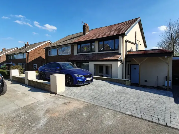 Cream rendered house with blue car