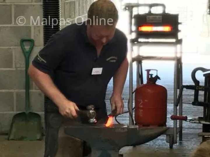 Farrier making a horse shoe