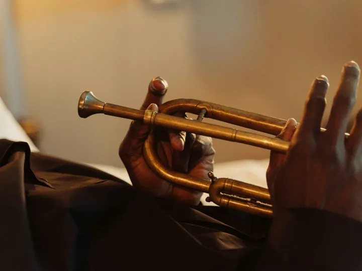 Artistic close-up of hands holding a brass trumpet, showcasing musical craftsmanship.