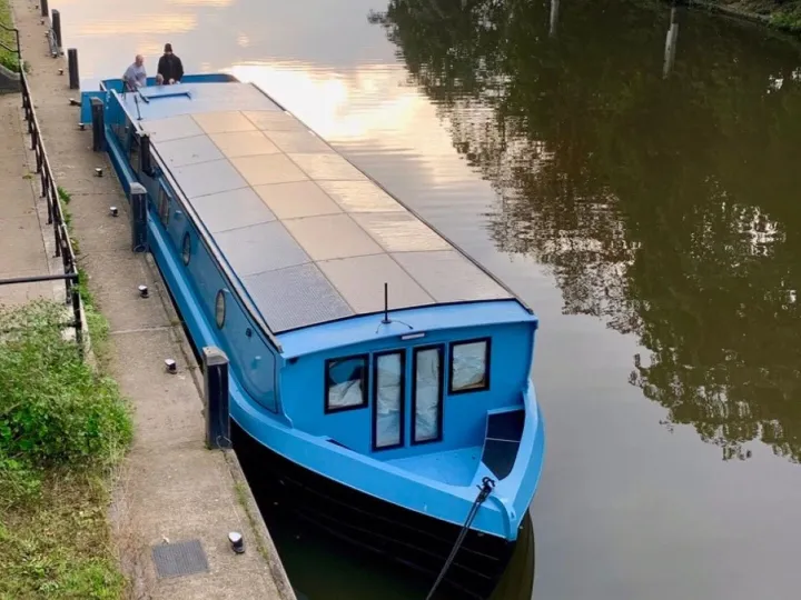 Blue solar-powered electric boat moored up to the shore