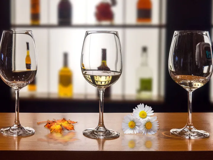 Wine glasses on a table with daisies