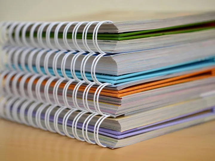 A colorful stack of spiral-bound notebooks neatly