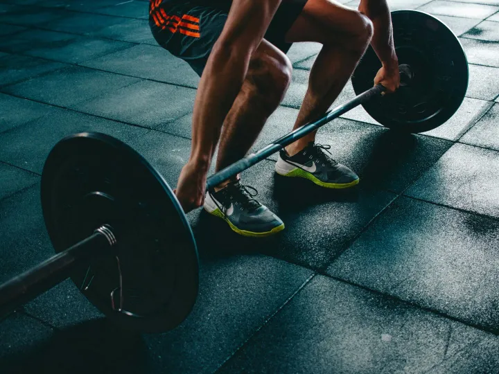 Man performing a deadlift exercise in a gym, demon