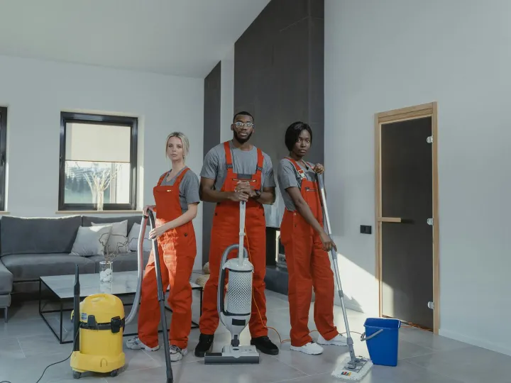 Diverse cleaning team in red uniforms ready to san