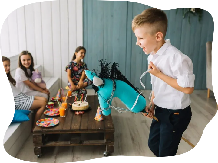 Boy riding hobby horse on birthday party