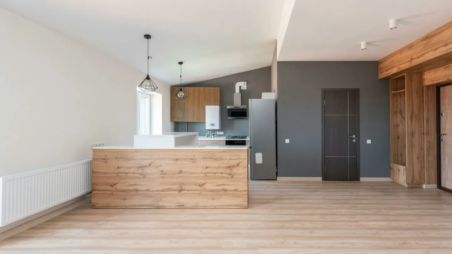 Explore a stylish and minimalistic open-plan kitchen with wood accents and modern design.